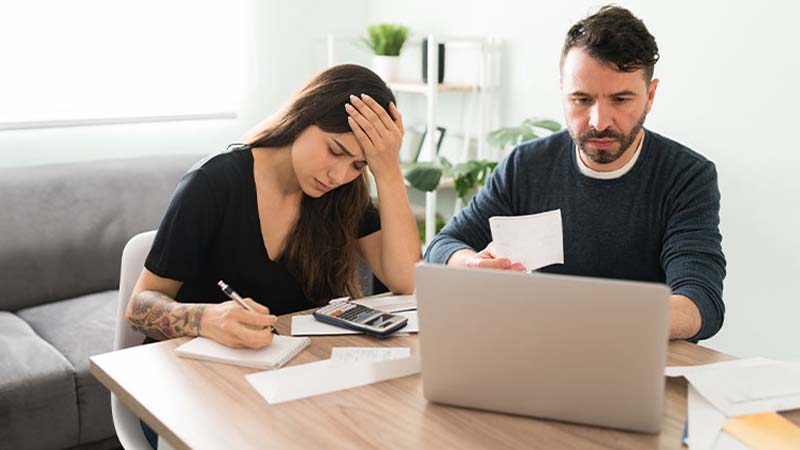 Casal em frentre a um portátil com ar preocupado